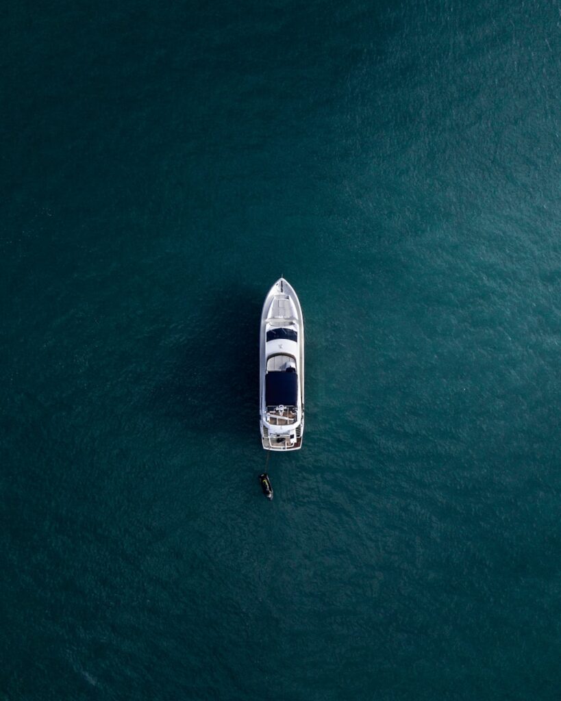 Luftbildaufnahme einer weißen Yacht auf ruhigem Wasser